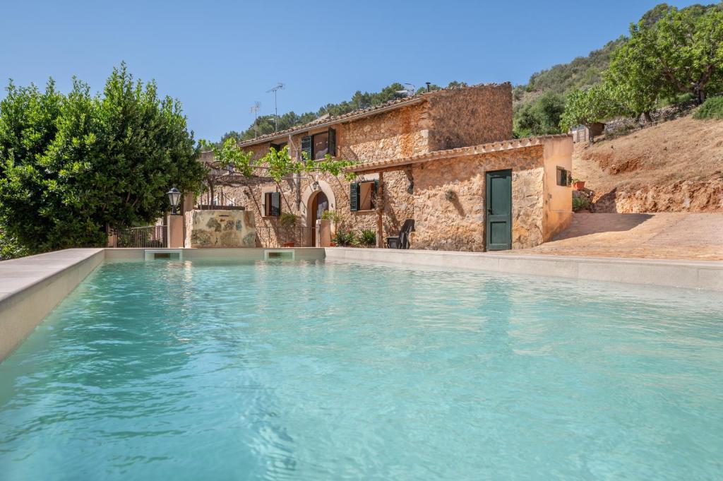 a swimming pool with blue water in front of a building at Casa Caimari in Caimari