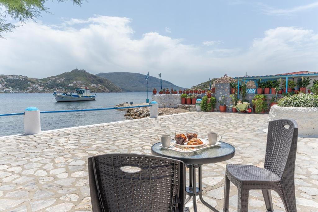 a table with a plate of food on it next to the water at Peter's Paradise in Telendos