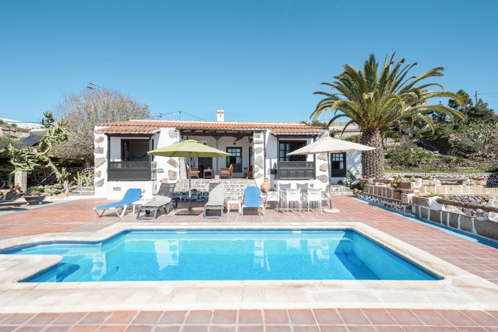a villa with a swimming pool and a house at La Cuadra de Arona in Arona