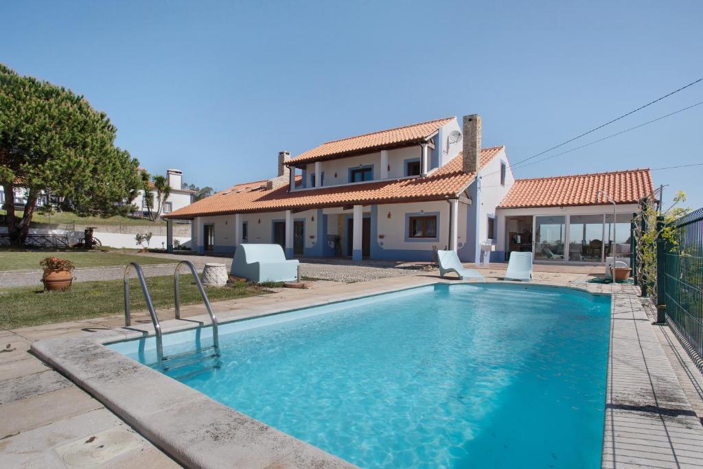 a villa with a swimming pool in front of a house at Melquites Country House in Barrantes