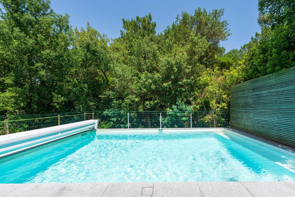 a swimming pool in a backyard with trees at Villa Piscine Entre Lac et Océan in Soorts-Hossegor