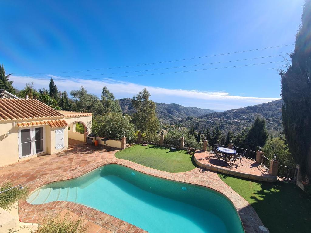 a house with a swimming pool and a yard at Casa tranquila torrox in Cómpeta