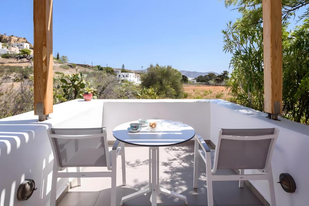 a patio with a table and chairs on a balcony at Echinousa Kimolos katoikia no6 in Kimolos