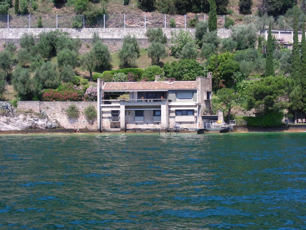 ein Haus am Ufer eines Wasserkörpers in der Unterkunft Villa Coccodrilla in Toscolano-Maderno