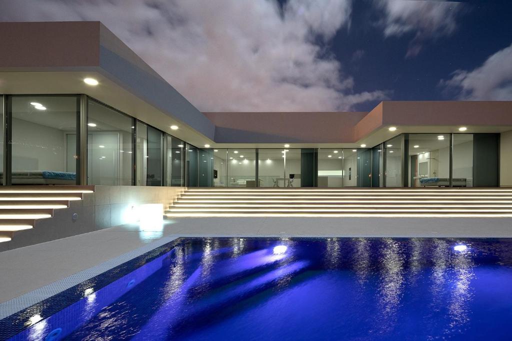 an empty house with a swimming pool at night at Villa Camacho - Ultra Luxury in Calheta