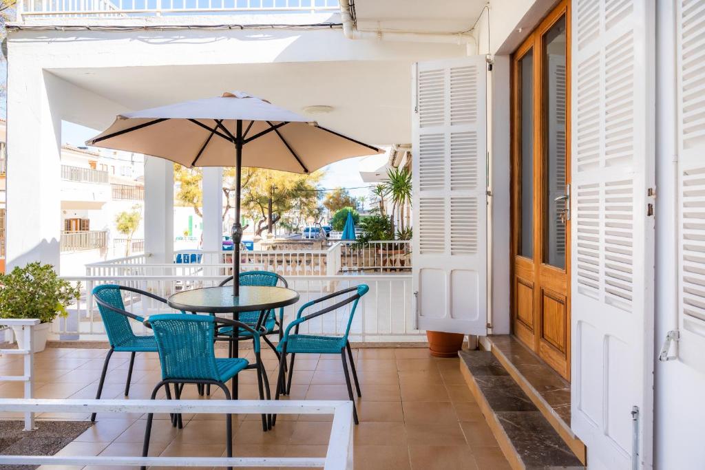 a patio with a table and chairs and an umbrella at Can Miquel in Can Picafort