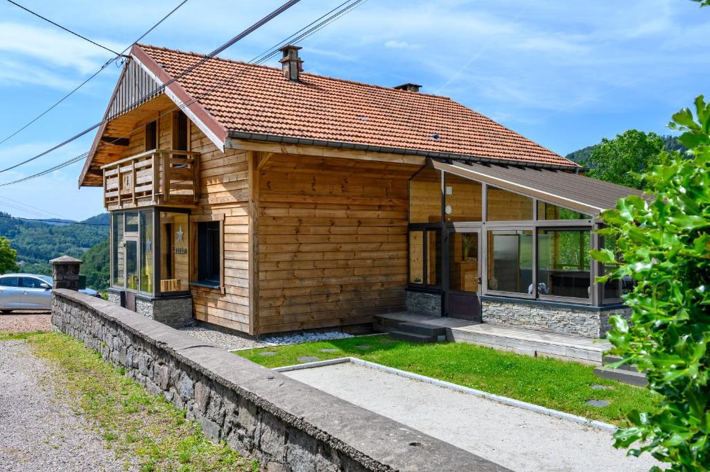 a small wooden house with a roof at Chalet le Brusyna avec jacuzzi in Saint-Maurice-sur-Moselle