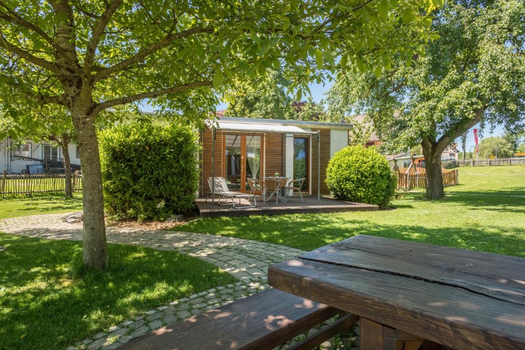 a wooden bench in a yard with a house at Ferienhaus Am Heidenbach in Deggenhausertal