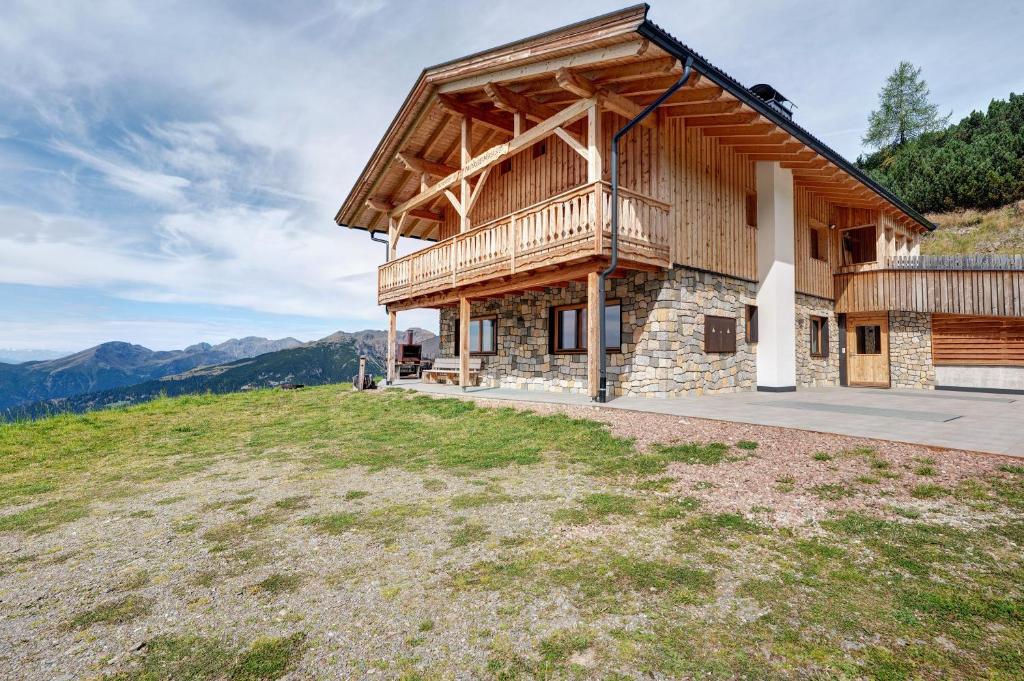 a log house with a balcony on a hill at Almhaus Morgenrast in Sarntal