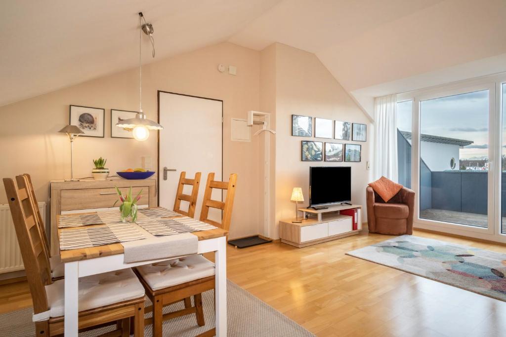 a dining room and living room with a table and chairs at Schwippl in Meckenbeuren