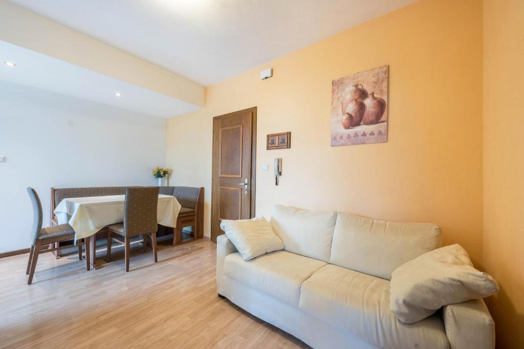 a living room with a white couch and a table at Residence Kronstein - Fewo 2 in Tesimo