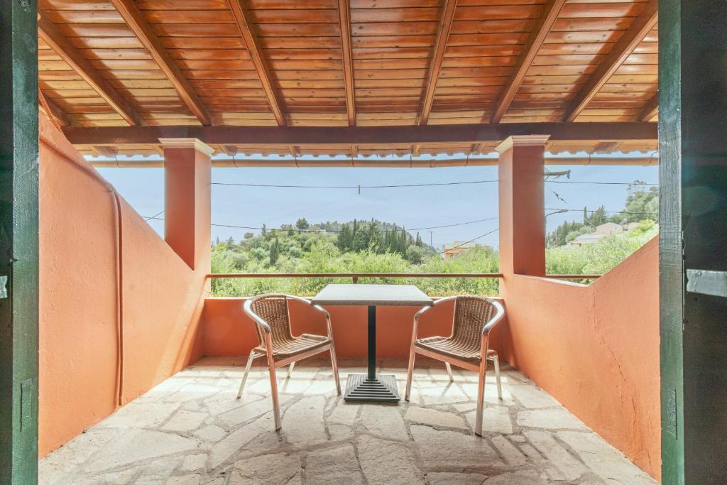 a table and chairs on a balcony with a view at Arianna Studio Ground Floor 7 in Paleokastritsa