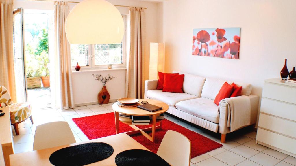 a living room with a white couch and red pillows at Solveigs Ferienwohnung in Bad Münstereifel
