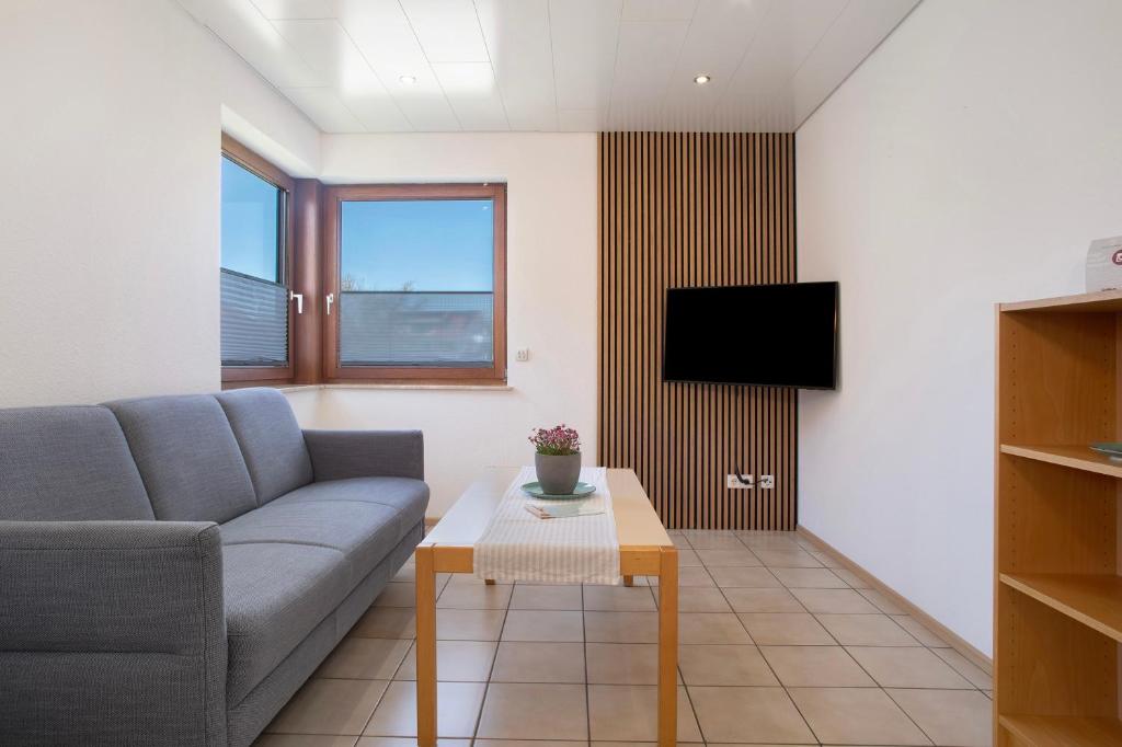 a living room with a couch and a table at Gästehaus Heinemann - Og4 in Langenargen