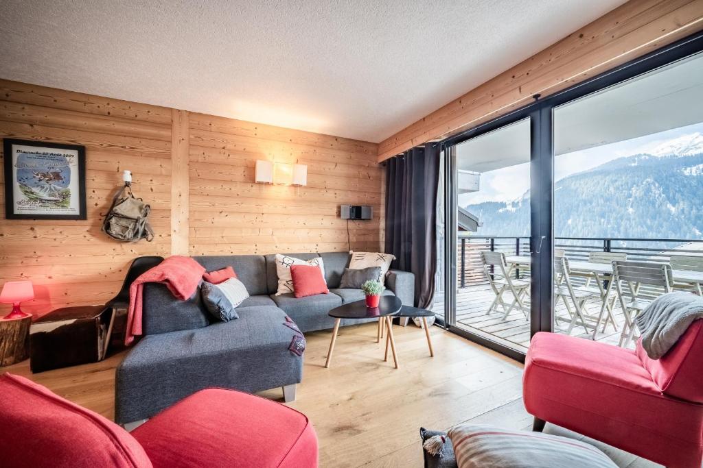 ein Wohnzimmer mit Sofa und großem Fenster in der Unterkunft Erin Roca immmobilier chatel boude in Châtel