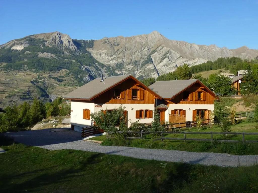 a house on a hill with mountains in the background at Deux grands chalets communicants in Les Orres