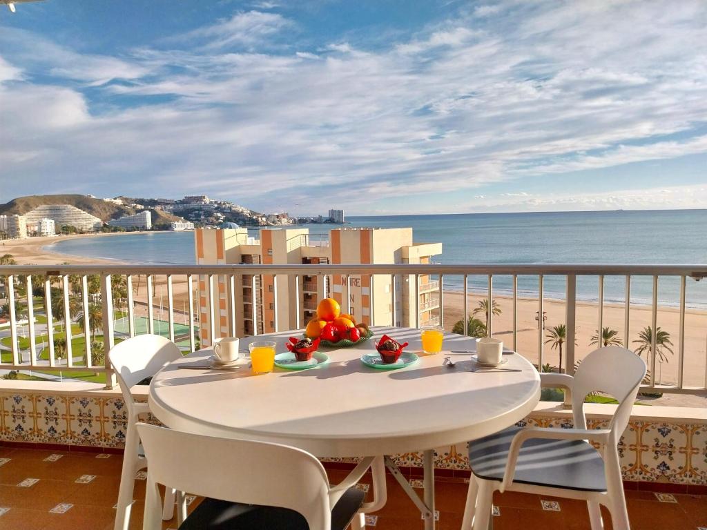 a table and chairs on a balcony with a view of the beach at Nereidas Beachfront in Cullera