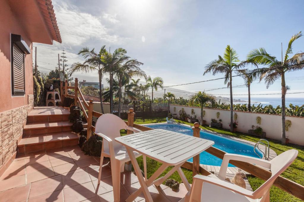 a patio with a table and chairs next to a swimming pool at Casa Victor - Apartment 4 in La Orotava