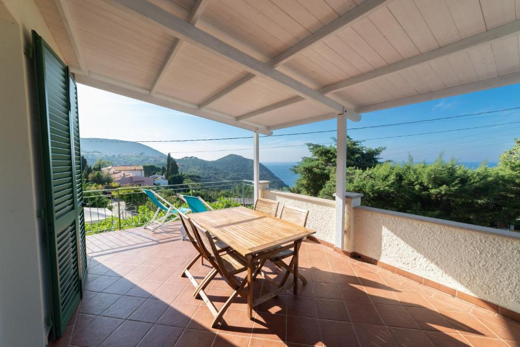 a patio with a wooden table and chairs on a balcony at Il Cisto in Marciana