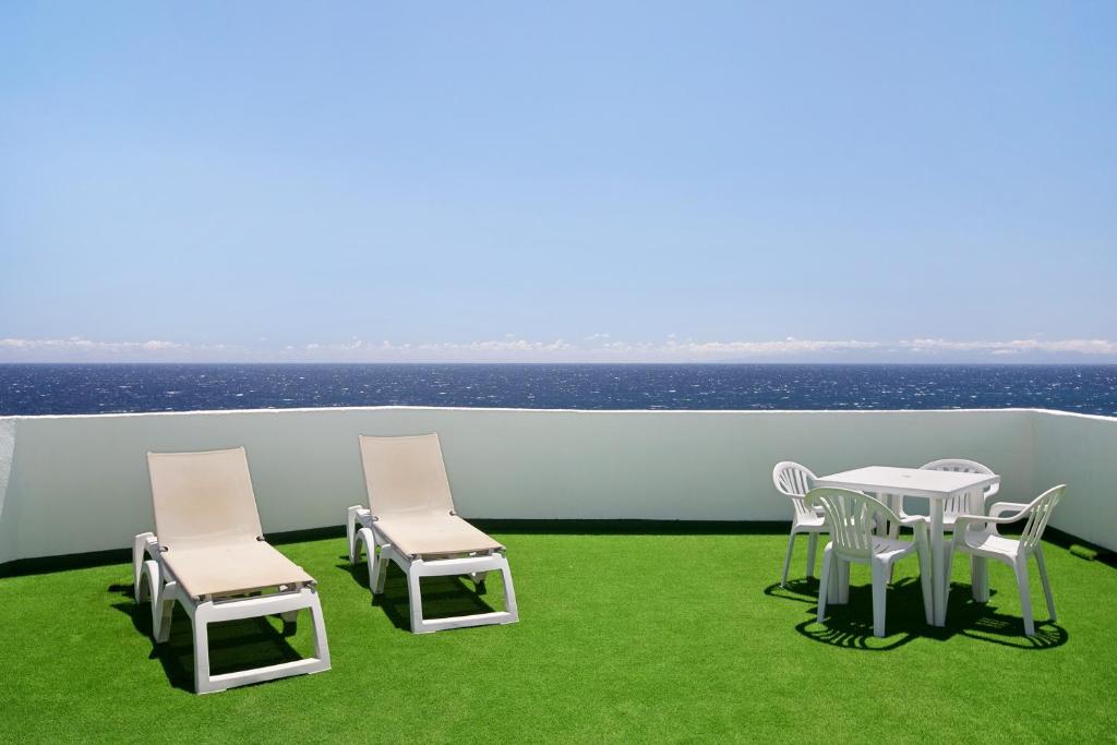 a balcony with a table and chairs and the ocean at Casa Fefa in Candelaria