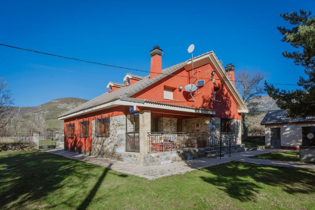 a house with a red roof on a yard at El Corcal in Triollo