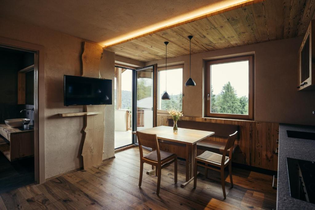 a dining room with a table and chairs and a television at Obertimpflerhof Wohnung Rosi in Verano