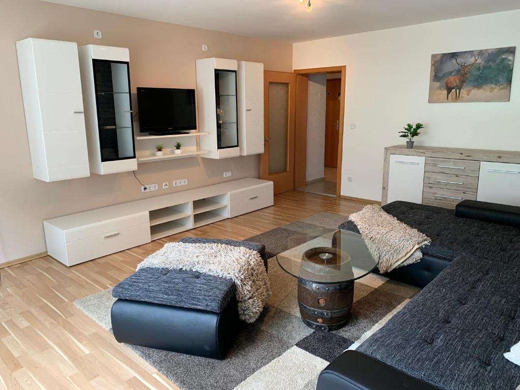 a living room with a couch and a tv at Ferienwohnung Ödbach mit Terrasse in Konzell