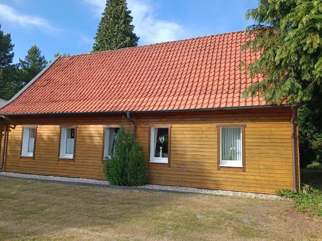 a small wooden house with an orange roof at Ferienwohnung Haarkotten in Steinfurt
