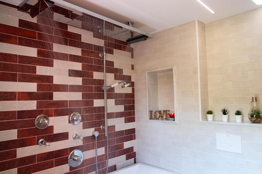 a bathroom with a shower with brown tiles at El Bosque in Candamin