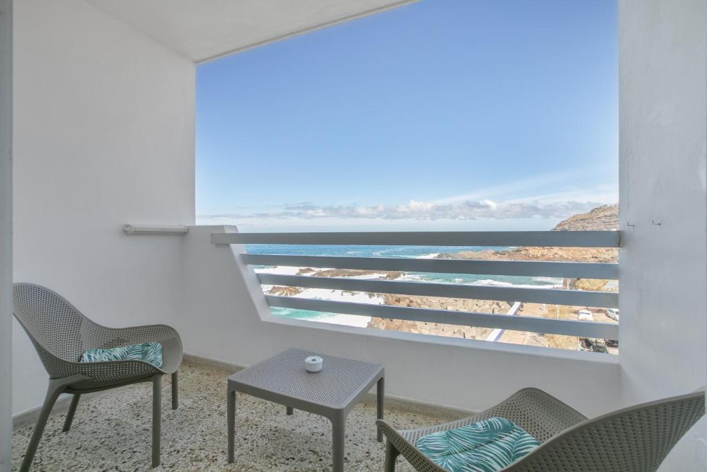 a room with chairs and a view of the ocean at Vv Tamara Sunset Suite in Tacoronte