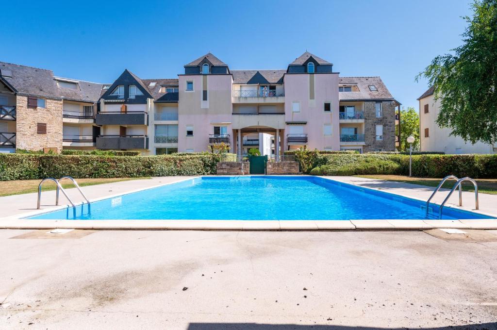 a swimming pool in front of a building at Le Sea Bird parking piscine été in Arzon