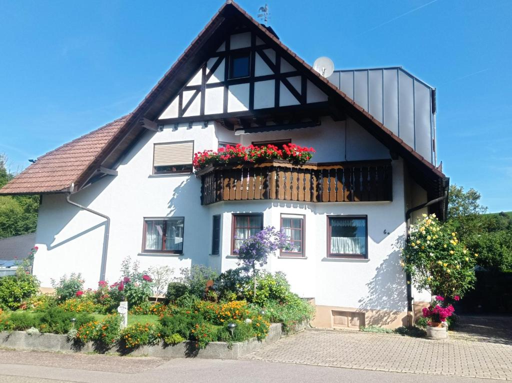 a white house with flowers on a balcony at Ferienwohnung Serr in Lauf