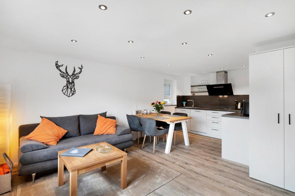a living room with a couch and a table at Fewo Weitblick - Haus Sommerberg in Baiersbronn