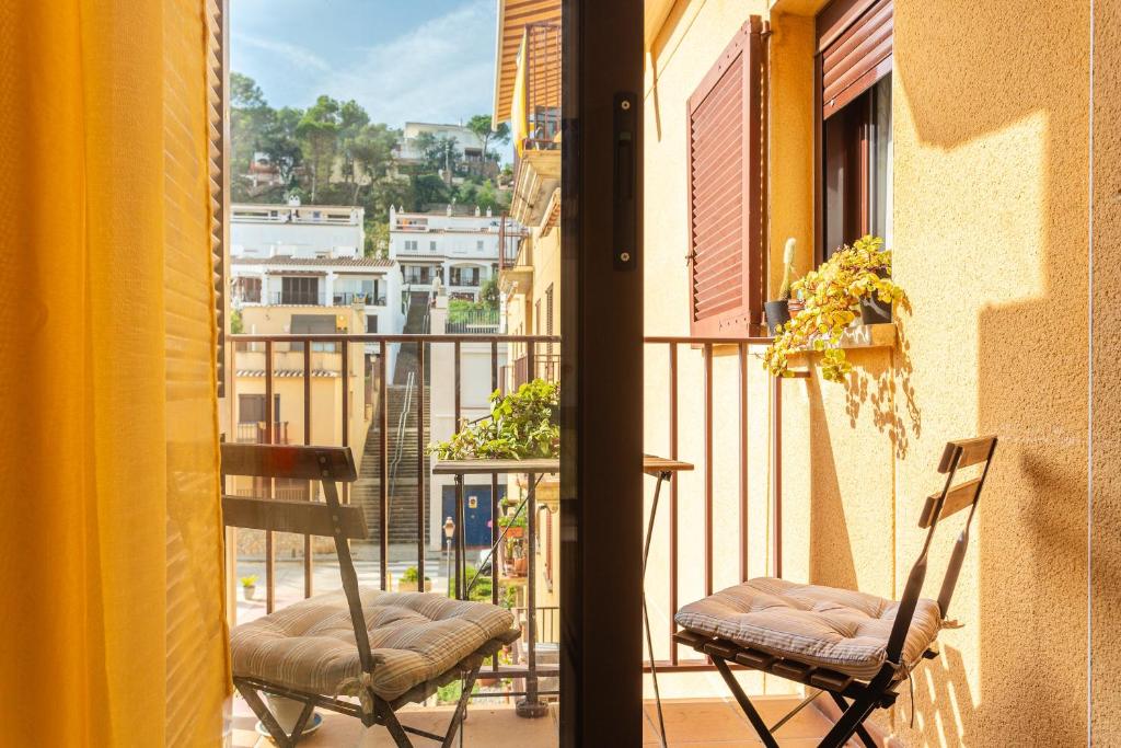 two chairs on a balcony with a view of a city at Can Maryel in Tossa de Mar