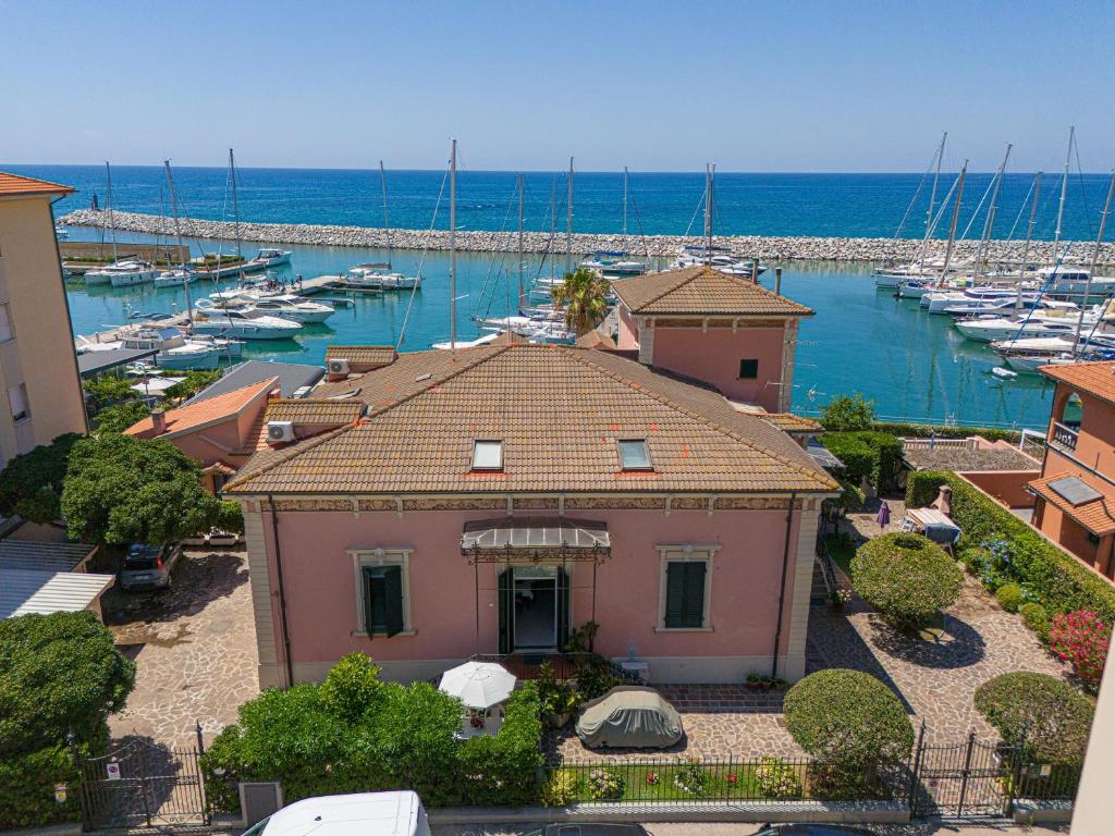 a pink house in a harbor with boats in the water at Villa Liberty Rosa 1912 in San Vincenzo