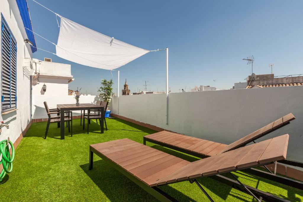 a patio with a table and chairs on a balcony at Freedom Penthouse in Seville