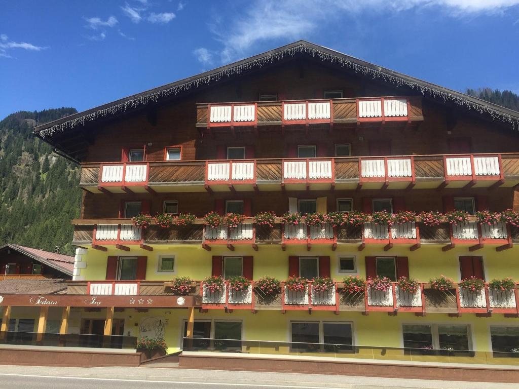 a large building with flower boxes on the balconies at Fedaia Joy Bnb in Canazei