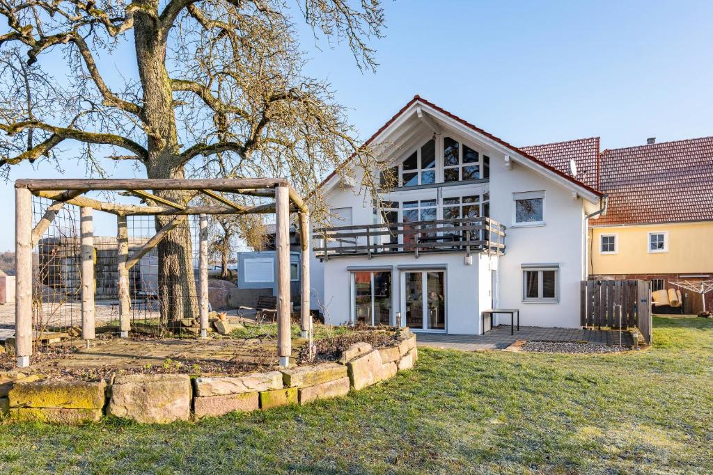 a house with a tree in front of it at Ferienwohnung Seyfried in Hardheim