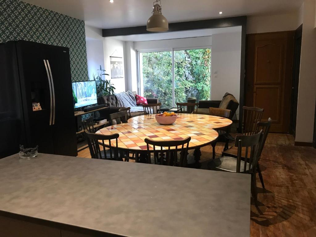a dining room with a table and chairs and a kitchen at Vacance 16 Pers in La Bourboule