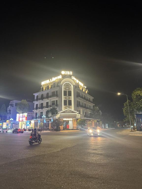 a lit up building on a city street at night at Khách sạn Lâm Hà - Laha Hotel in Riong Serignac