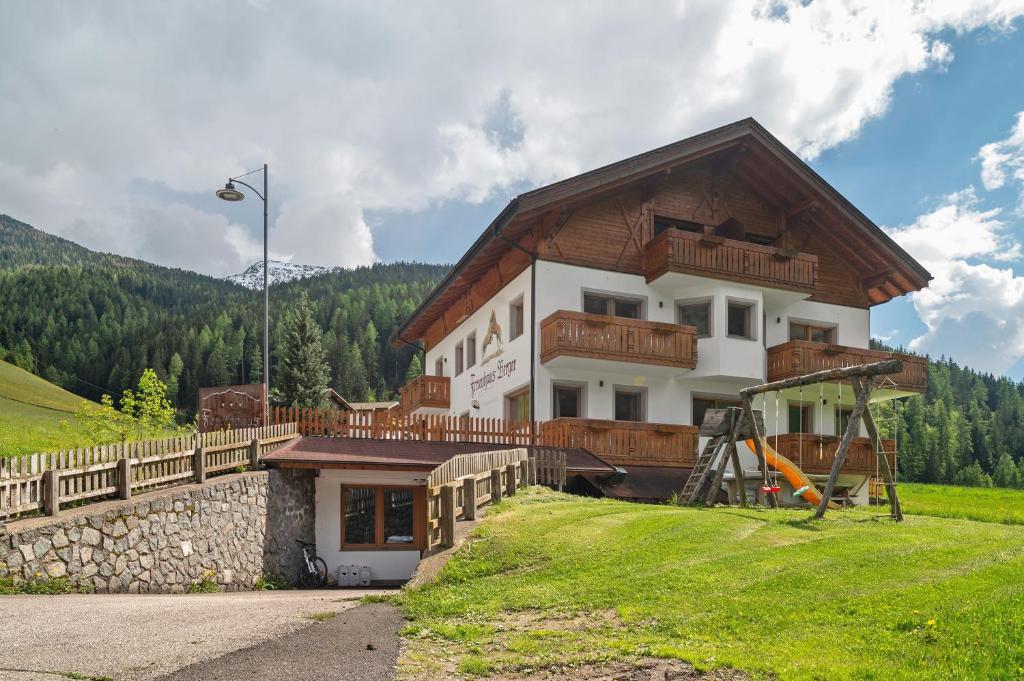 a house with a wooden roof on a hill at Ferienhaus Berger in Sarntal