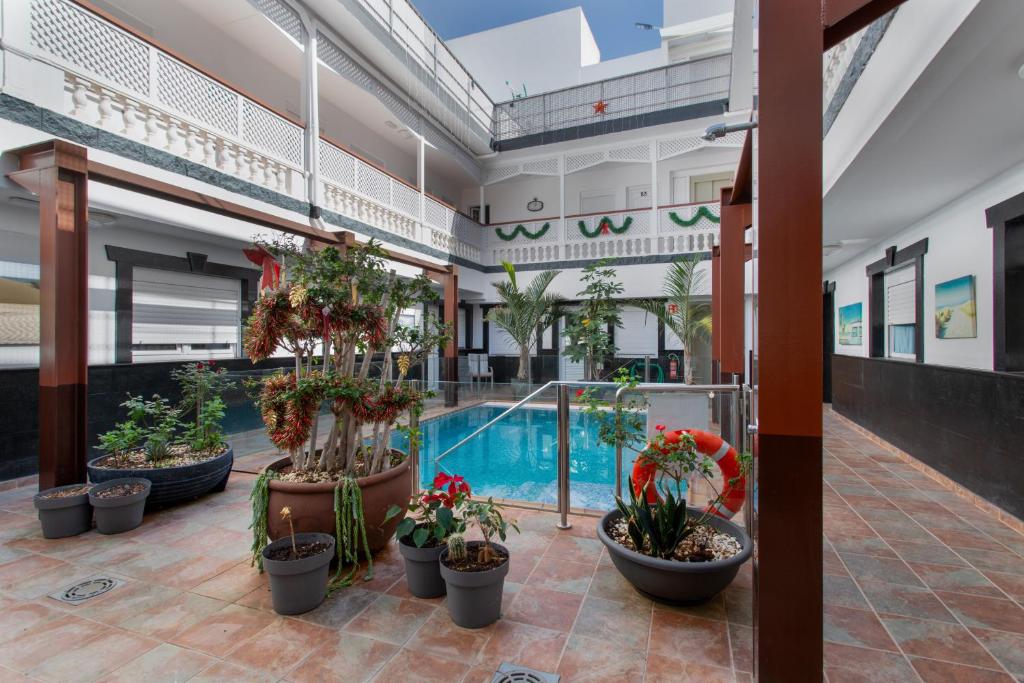 a large building with a pool and potted plants at Casa Paula - 21 in Arinaga