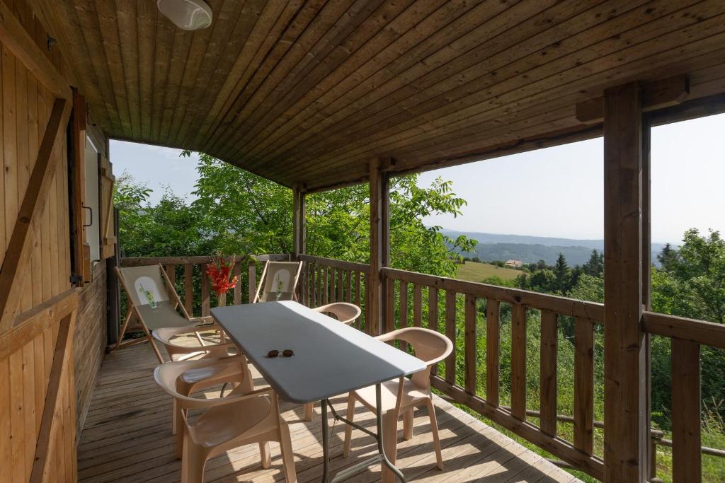 a wooden deck with a table and chairs on it at Maison Jordan - Mas Lachamp in Gravières