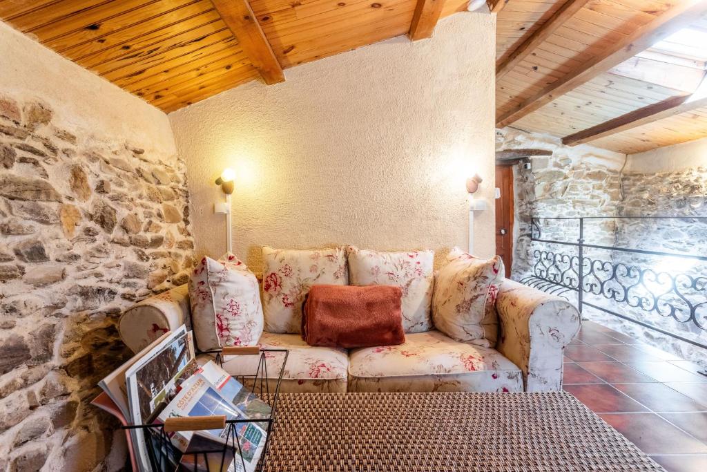 a living room with a couch and a stone wall at La Fenière - Maison avec terrasse in Collobrières
