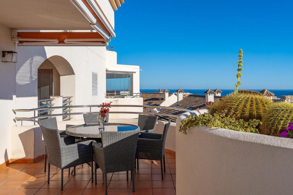 a balcony with a table and chairs and the ocean at Vistolmar Tivoli A213 in Benalmádena