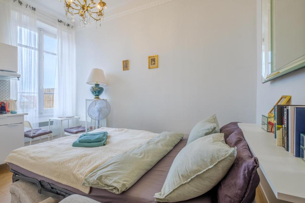 a bed with pillows on it in a room at Joli studio près de Monaco in Beausoleil