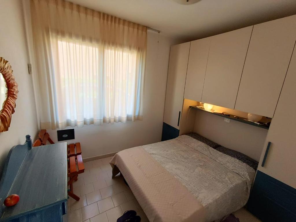 a small bedroom with a bed and a window at App Casa Dei Pini - Bilocale in Capoliveri
