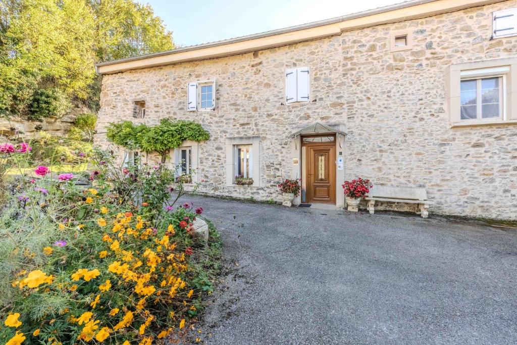a stone house with a bench in front of it at Gite du Moulin - Ariège in Carla-de-Roquefort