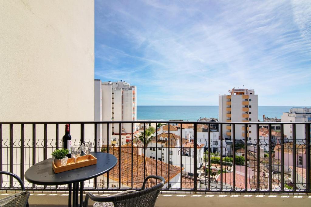 a balcony with a table and a view of the ocean at Luxury Beach View - Praia da Rocha in Portimão