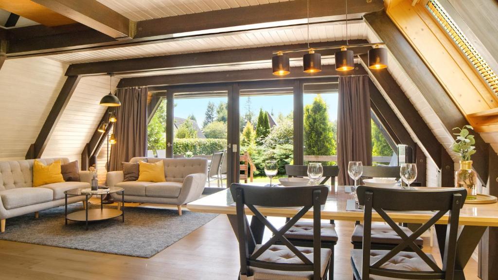 a living room with a dining room table and chairs at Ferienhaus Auszeit mit Terrasse in Tennenbronn